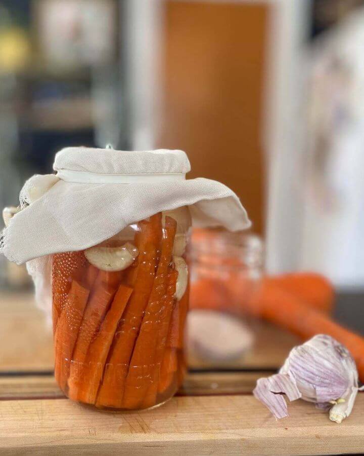 Fermented carrots with garlic, covered with a cheesecloth.