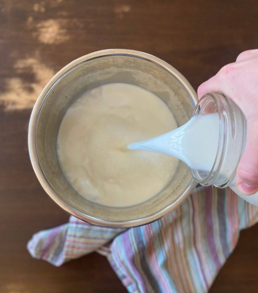 the-humming-homemaker-instant-pot-greek-yogurt-pouring-milk Pouring milk into an Instant Pot to make Greek yogurt.