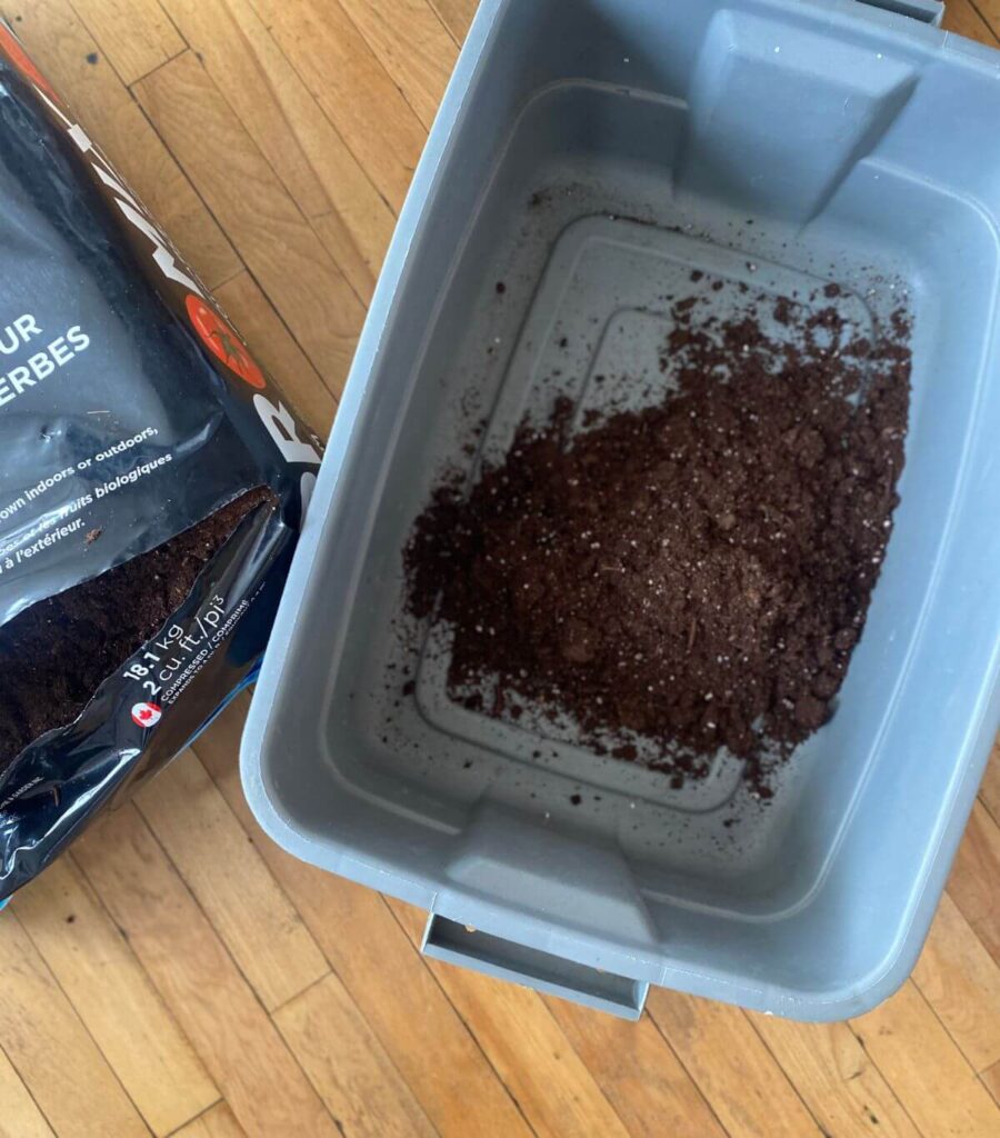 Pouring soil into a large bin.