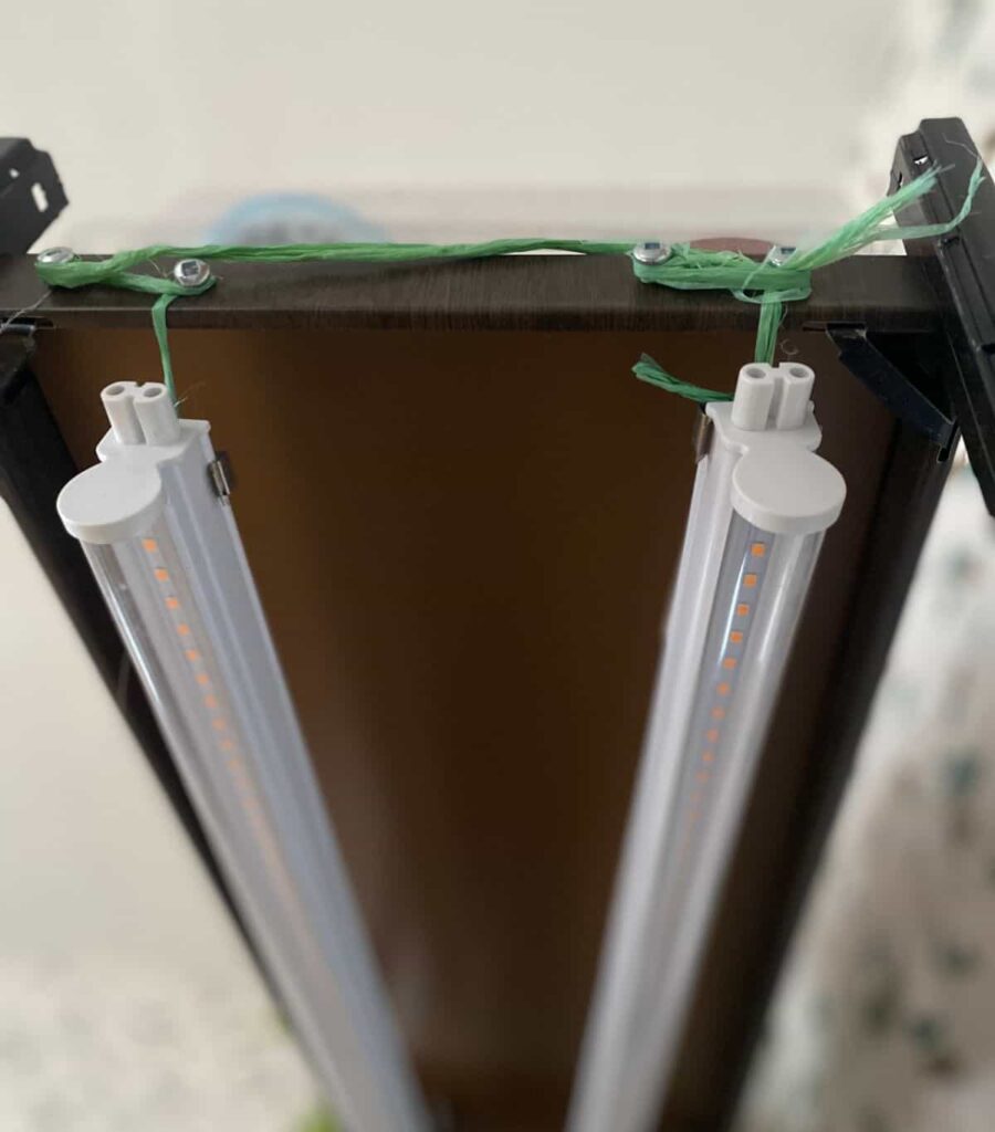 Close up of grow lights hanging from a shelf.