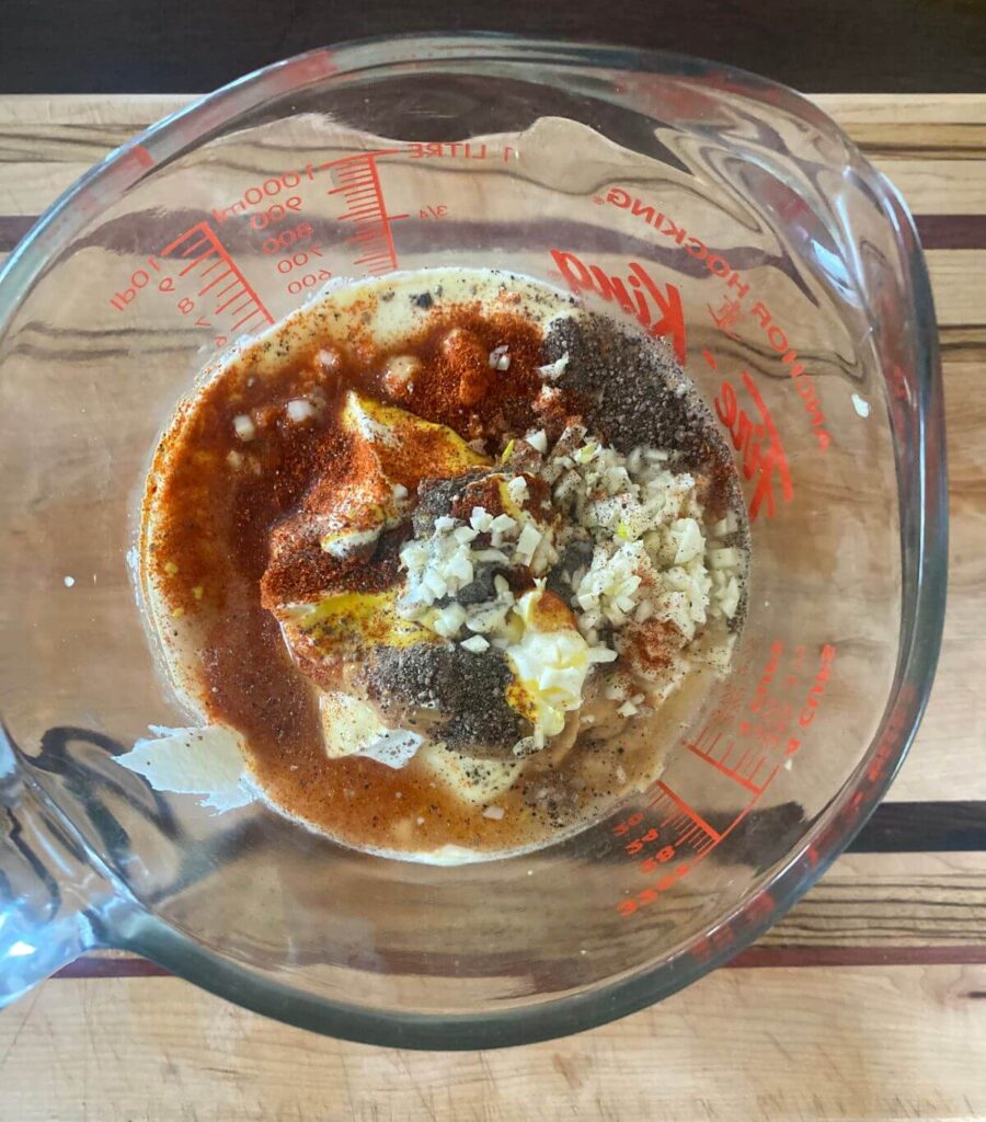 Making the dressing for loaded potato salad - all ingredients in a glass measuring cup about to be mixed.